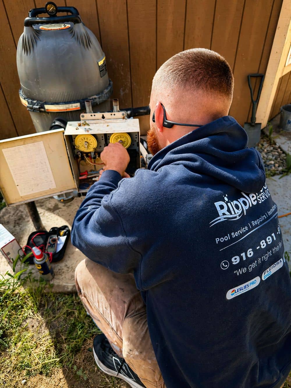 Ripple Pool Service technician adjusting a pool timer beside a cartridge filter